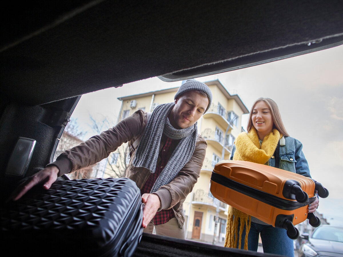 A family with luggage beside a taxi on a London street
